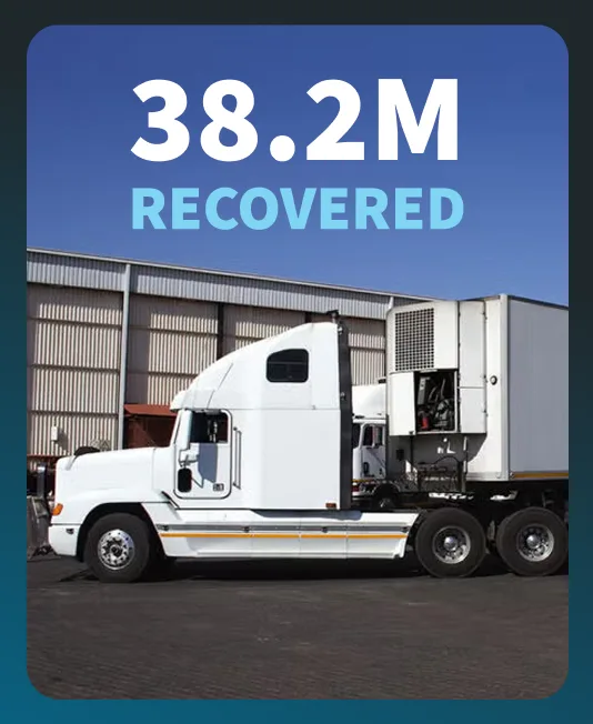 A white semi-truck with a refrigerated trailer parked beside a warehouse, overlaid with the figure 38.2M recovered.
